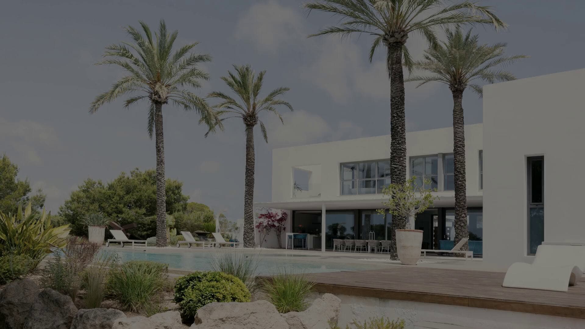 A Mediterranean coastal villa in warm natural light, limestone and plaster opening toward the sea